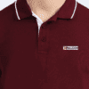 Rear side of a maroon collared t-shirt with white trim on sleeves