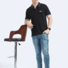 Standing view of a man wearing a navy blue polo t-shirt